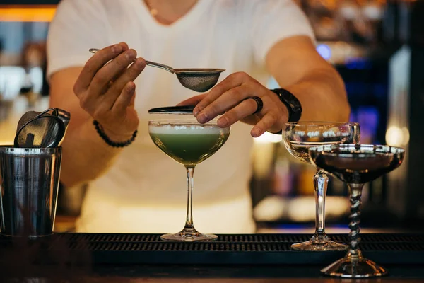 Foco seletivo do bartender preparando coquetel alcoólico usando peneira — Fotografia de Stock