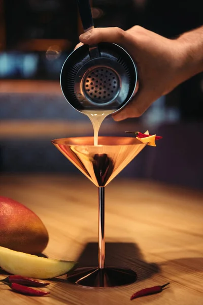 Selektiver Fokus des Barkeepers, der Cocktails aus dem Shaker durch ein Sieb in Metallglas gießt — Stockfoto