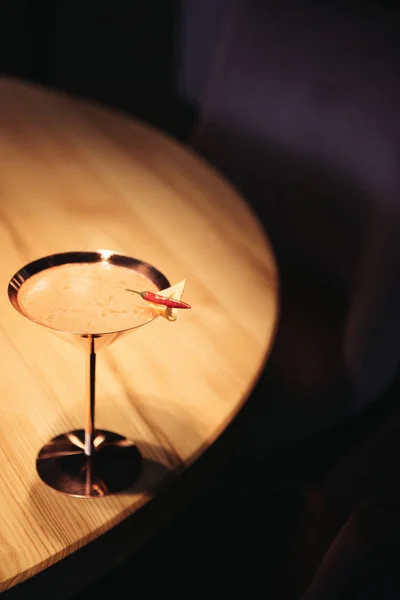 Alcoholic cocktail in metal glass decorated with chili pepper and nacho chip on wooden table — Stock Photo