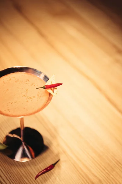 Foyer sélectif de cocktail alcoolisé en verre métallique décoré de piment et de copeaux de nacho sur table en bois — Photo de stock