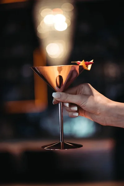 Abgeschnittene Ansicht einer Frau mit einem alkoholischen Cocktail in Metallglas mit Nacho-Chip und Chilipfeffer auf dunklem Hintergrund — Stockfoto