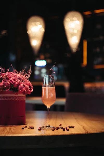 Selective focus of pink alcoholic cocktail with flowers on dark background — Stock Photo