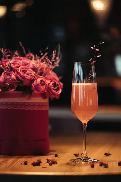 Selective focus of pink alcoholic cocktail with flowers on dark background — Stock Photo