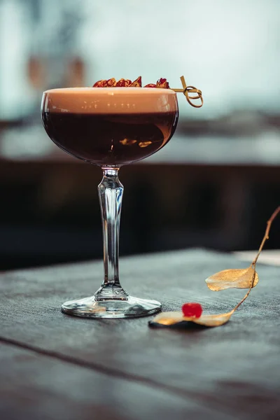 Selective focus of alcoholic cocktail with foam and dry flowers on dark background — Stock Photo