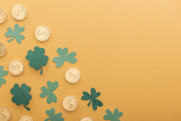 Top view of golden coins with dollar signs, shamrocks and copy space isolated on orange, st patrick day concept — Stock Photo