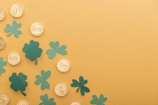 Vista superior de moedas de ouro com sinais de dólar, trevos e espaço de cópia isolado em laranja, st patrick conceito dia — Fotografia de Stock