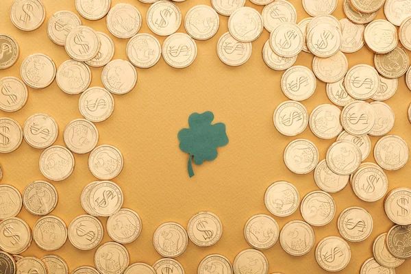 Vue du dessus des pièces d'or avec des signes de dollar et le trèfle isolé sur l'orange, concept st patrick jour — Photo de stock