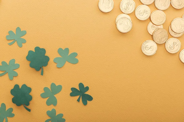 Vista superior de moedas de ouro com sinais de dólar, trevos e espaço de cópia isolado em laranja, st patrick conceito dia — Fotografia de Stock