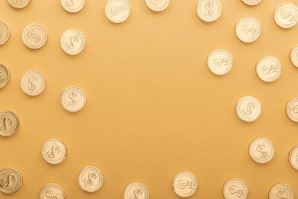 Top view of shiny golden coins with dollar signs isolated on orange with copy space, st patrick day concept — Stock Photo