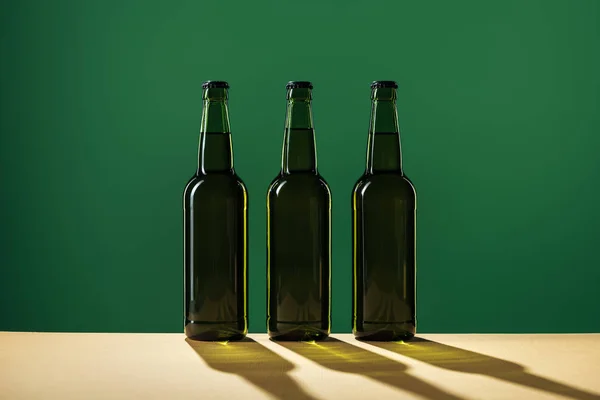 Bouteilles de bière avec ombres isolées sur vert, concept st patrick jour — Photo de stock