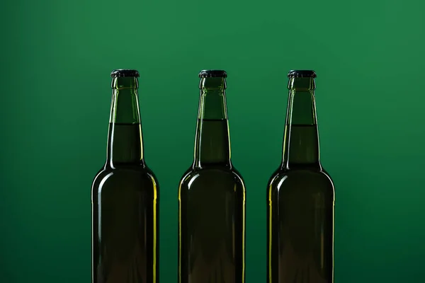 Reihe von Bierflaschen isoliert auf grünem, st patrick day Konzept — Stockfoto