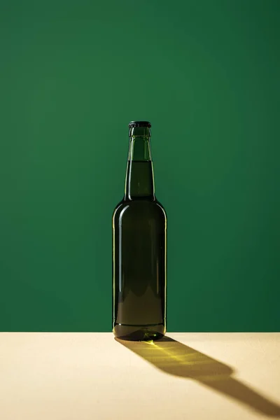 Beer bottle with shadow isolated on green, st patrick day concept — Stock Photo