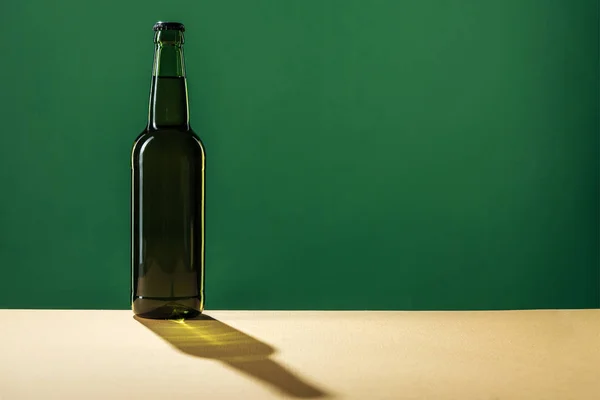 Bottiglia di birra con ombra e spazio copia isolato sul verde, concetto giorno st patrick — Foto stock