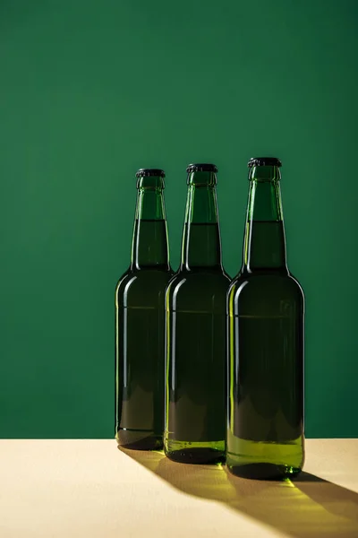 Bouteilles de bière avec ombres isolées sur vert, concept st patrick jour — Photo de stock