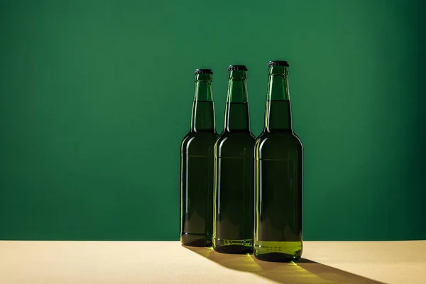 Botellas de cerveza con sombras y espacio de copia aislado en verde, San Patricio concepto de día - foto de stock