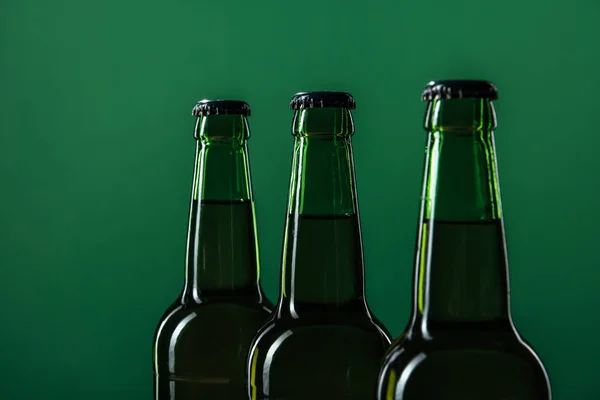 Fermer les bouteilles de bière isolées sur vert, concept st patrick jour — Photo de stock