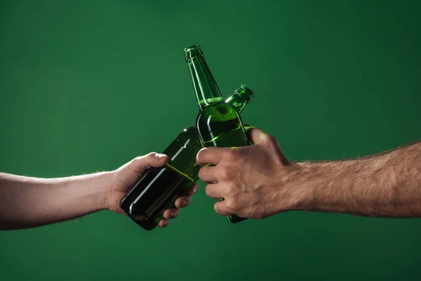 Обрізаний вид чоловіків, що смердять пляшки пива ізольовані на зеленому, Сент-Патрік концепція дня — стокове фото