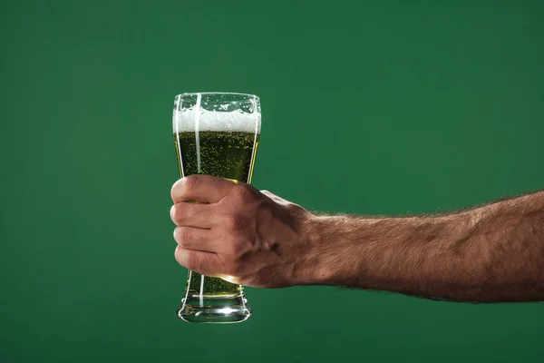 Обрізаний вид людини, що тримає келихи пива з піною ізольовані на зеленому, концепція дня святого Патріка — стокове фото