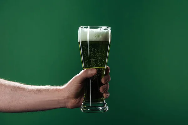 Cropped view of man holding glasses of beer with foam isolated on green, st patrick day concept — Stock Photo