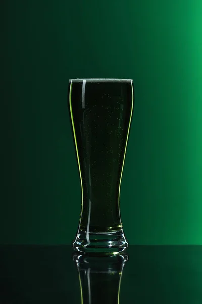 Glas Bier mit Schaum auf grünem Hintergrund, st patrick day concept — Stockfoto