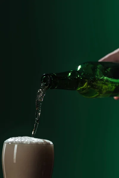 Bier in Glas gießen mit Schaumstoff isoliert auf grünem, st patrick day Konzept — Stockfoto