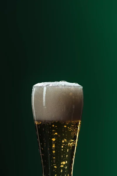 Пивний келих з піною та копіюванням простору ізольовано на зеленому, концепція дня святого Патріка — стокове фото