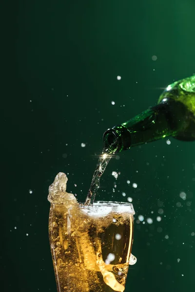 Лиття пива в склянку з бризками і копіювання простору ізольовано на зеленому, Сент-Патрік концепція дня — стокове фото