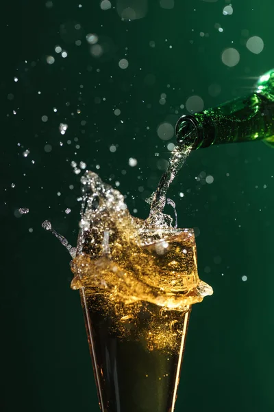Versando birra in vetro con spruzzi isolati su verde, concetto giorno di San Patrizio — Foto stock