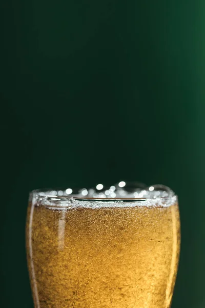 Enfoque selectivo de vidrio de cerveza aislado en verde con espacio de copia, San Patricio concepto de día - foto de stock