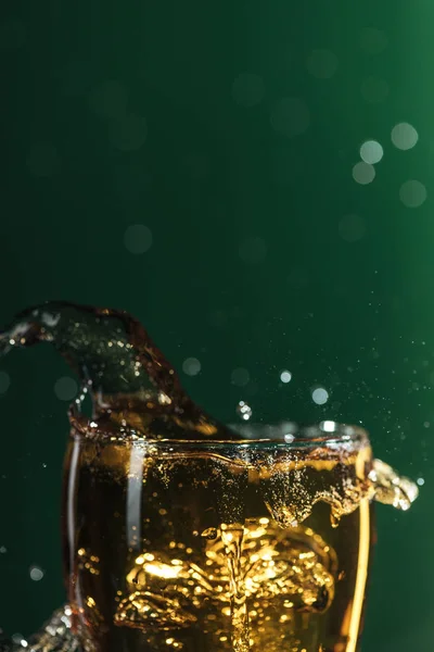 Bicchiere di birra con spruzzi isolati su verde con spazio copia, isolati su verde — Foto stock