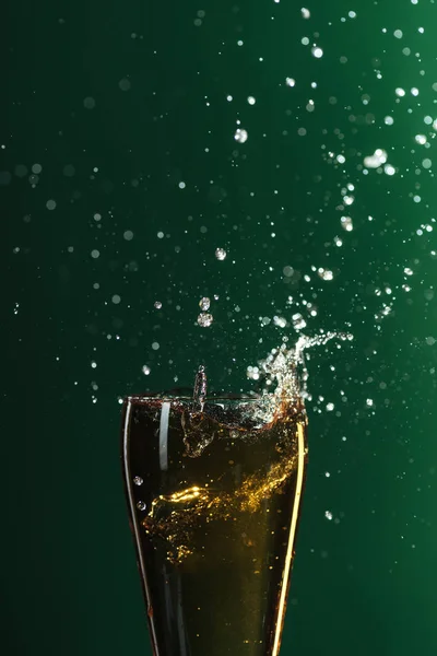 Bicchiere di birra fredda con spruzzi isolati su verde, concetto di giorno di San Patrizio — Foto stock