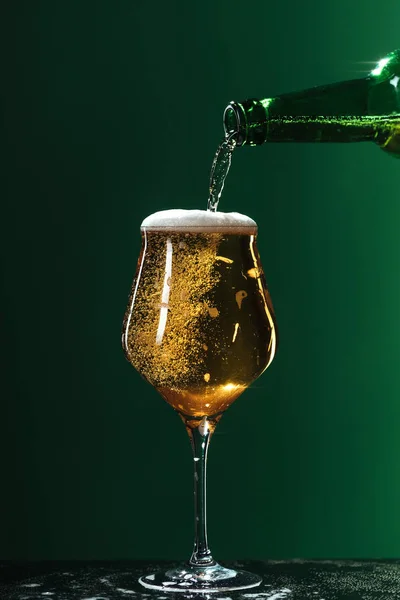 Bier in Glas gießen, isoliert auf grünem, st patrick day Konzept — Stockfoto