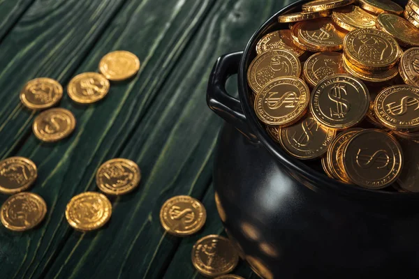 Moedas de ouro em pote preto no fundo de madeira, st patrick dia conceito — Fotografia de Stock