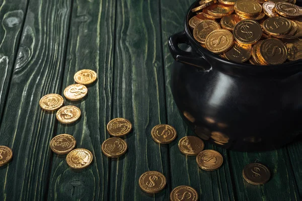 Золоті монети в чорному горщику на дерев'яному фоні, концепція дня святого Патріка — стокове фото