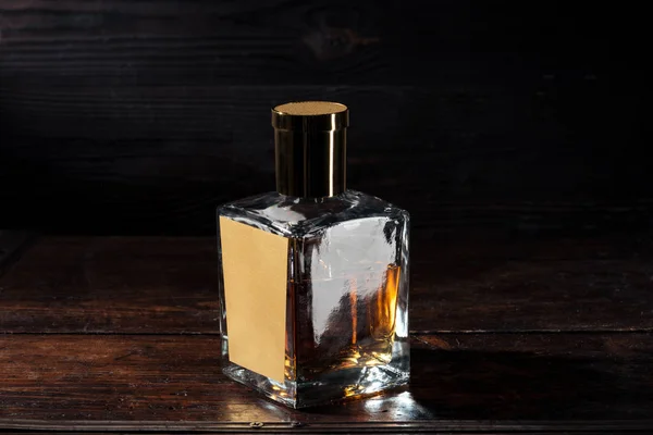 Close-up view of bottle of whisky with blank label on brown wooden table — Stock Photo