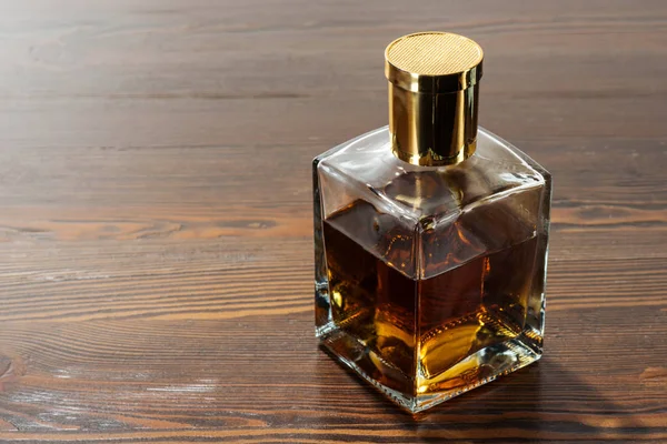 Bottle of luxury alcohol on brown wooden table — Stock Photo