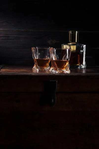 Botella y vasos de whisky en la mesa de madera vintage - foto de stock