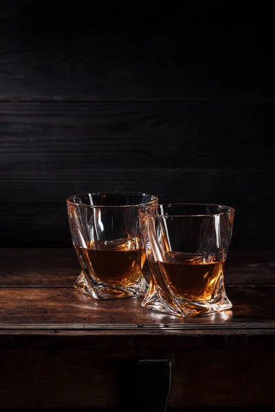 Dos vasos de whisky sobre mesa de madera marrón - foto de stock