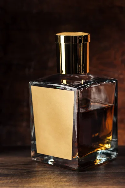 Nahaufnahme einer Luxus-Cognacflasche mit leerem Etikett auf Holztisch — Stockfoto