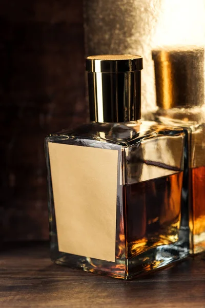 Nahaufnahme einer luxuriösen Whiskeyflasche mit leerem Etikett auf einem Holztisch — Stockfoto