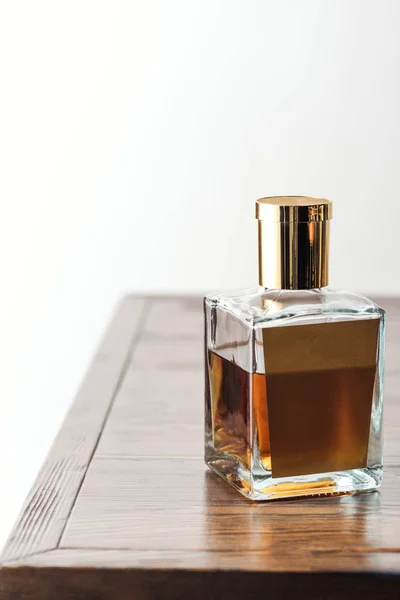 Vue rapprochée d'une bouteille de whisky de luxe sur table en bois isolée sur fond blanc — Photo de stock