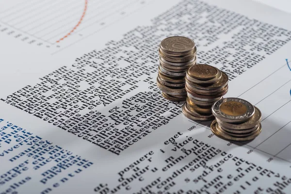 Enfoque selectivo de las pilas de monedas en el documento de texto con gráficos - foto de stock