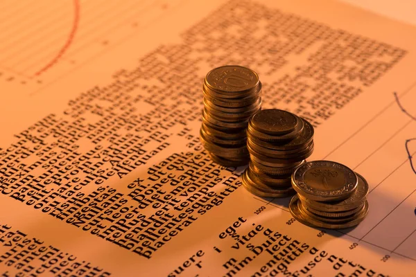 Enfoque selectivo de las pilas de monedas en el documento de texto con fondo borroso - foto de stock