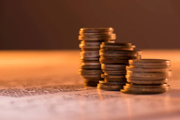 Enfoque selectivo de las pilas de monedas en el documento de texto y fondo borroso - foto de stock