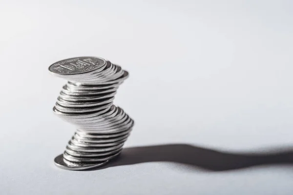 Pila curva de monedas ucranianas y sombra sobre fondo gris - foto de stock