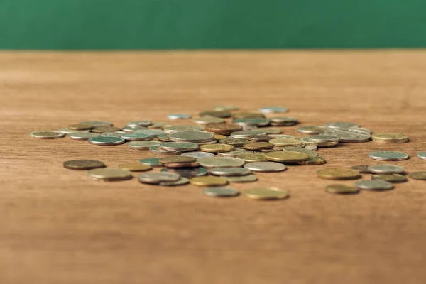 Enfoque selectivo de las monedas en la mesa de madera y fondo verde - foto de stock