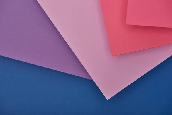 Top view of lilac, violet, blue and pink paper sheets with copy space — Stock Photo