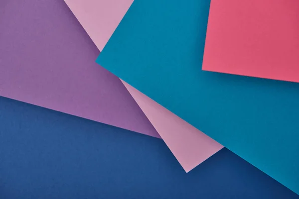 Vue de dessus des feuilles de papier violet, bleu et rose avec espace de copie — Photo de stock