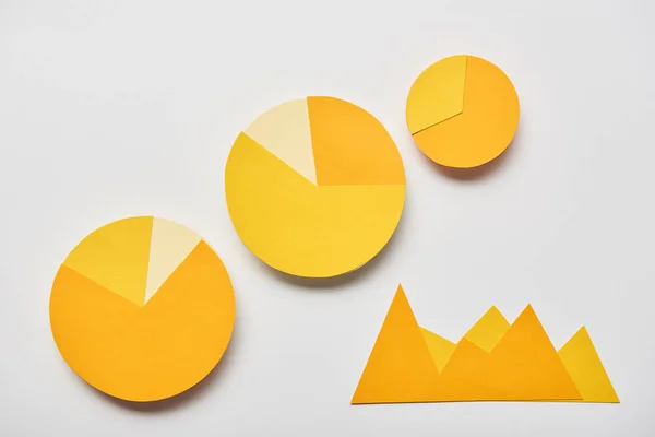 Top view of paper yellow charts and graphs on white background — Stock Photo