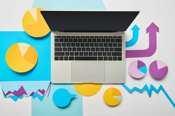 Top view of opened laptop with paper charts and graphs, pointers on white background — Stock Photo